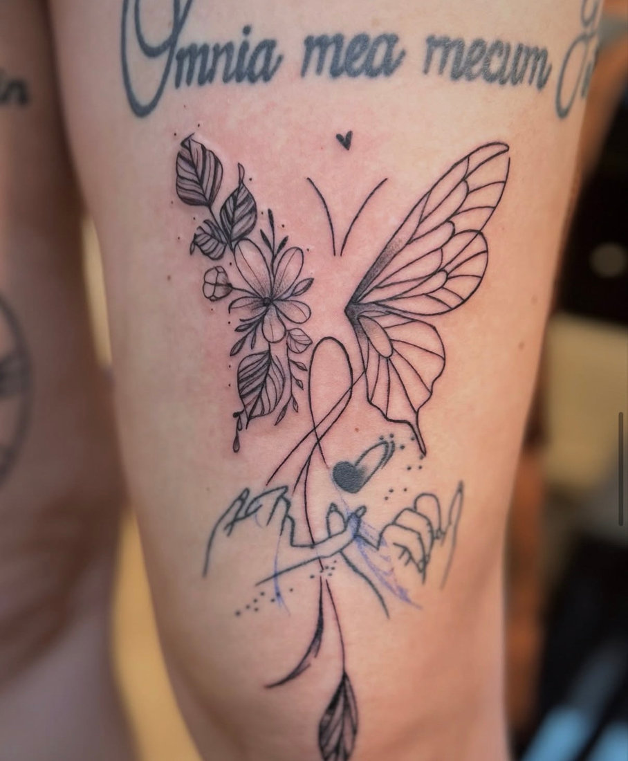 Butterfly, florals and script tattoo on the thigh