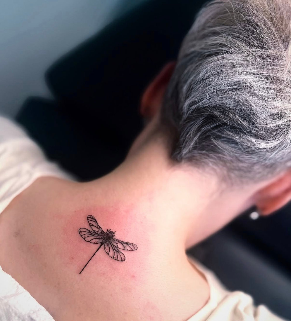 Fine line dragonfly tattoo on the nape