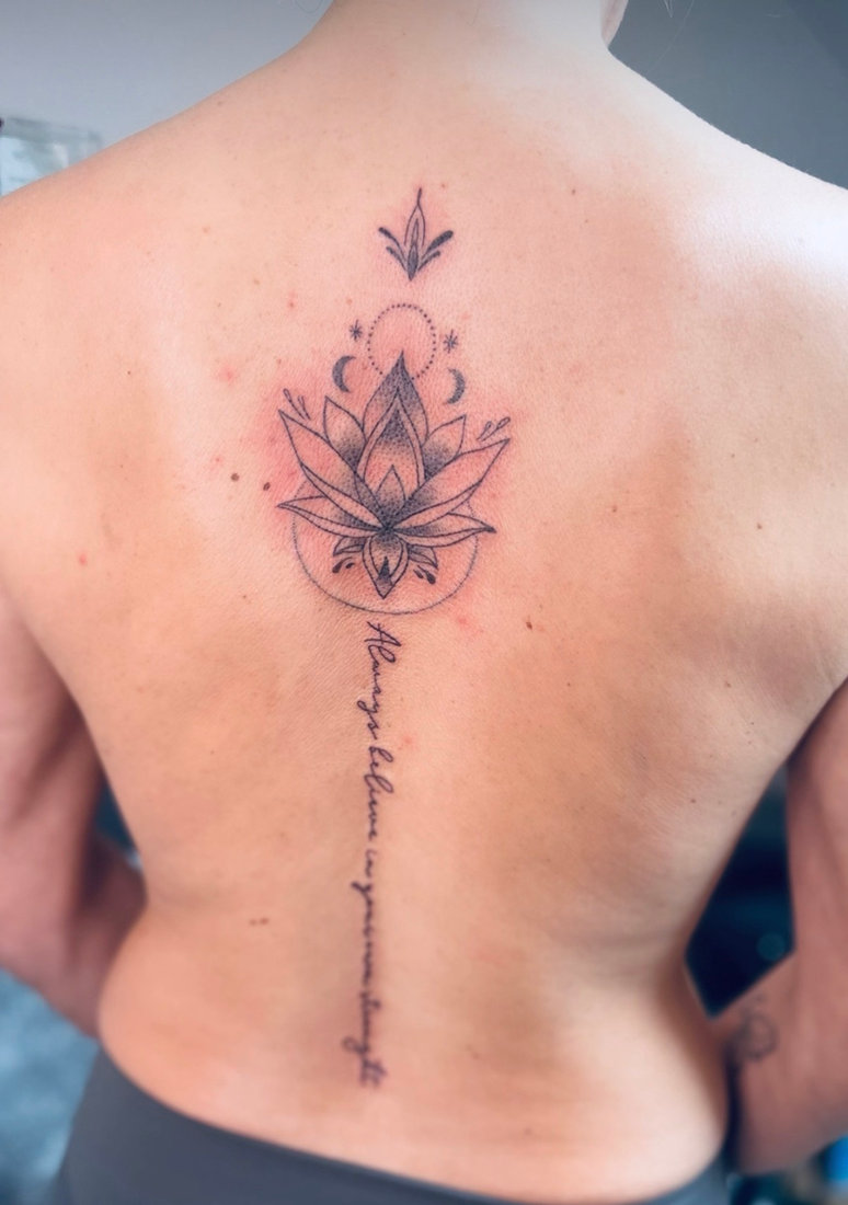 Lotus and mandala tattoo along the spine